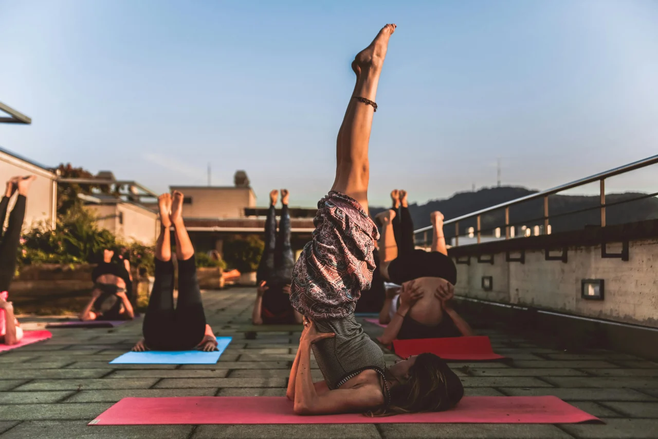 Yoga und Meditation 2 Gruppe macht Yoga auf einem Dach in einer Pose mit Beinen nach oben