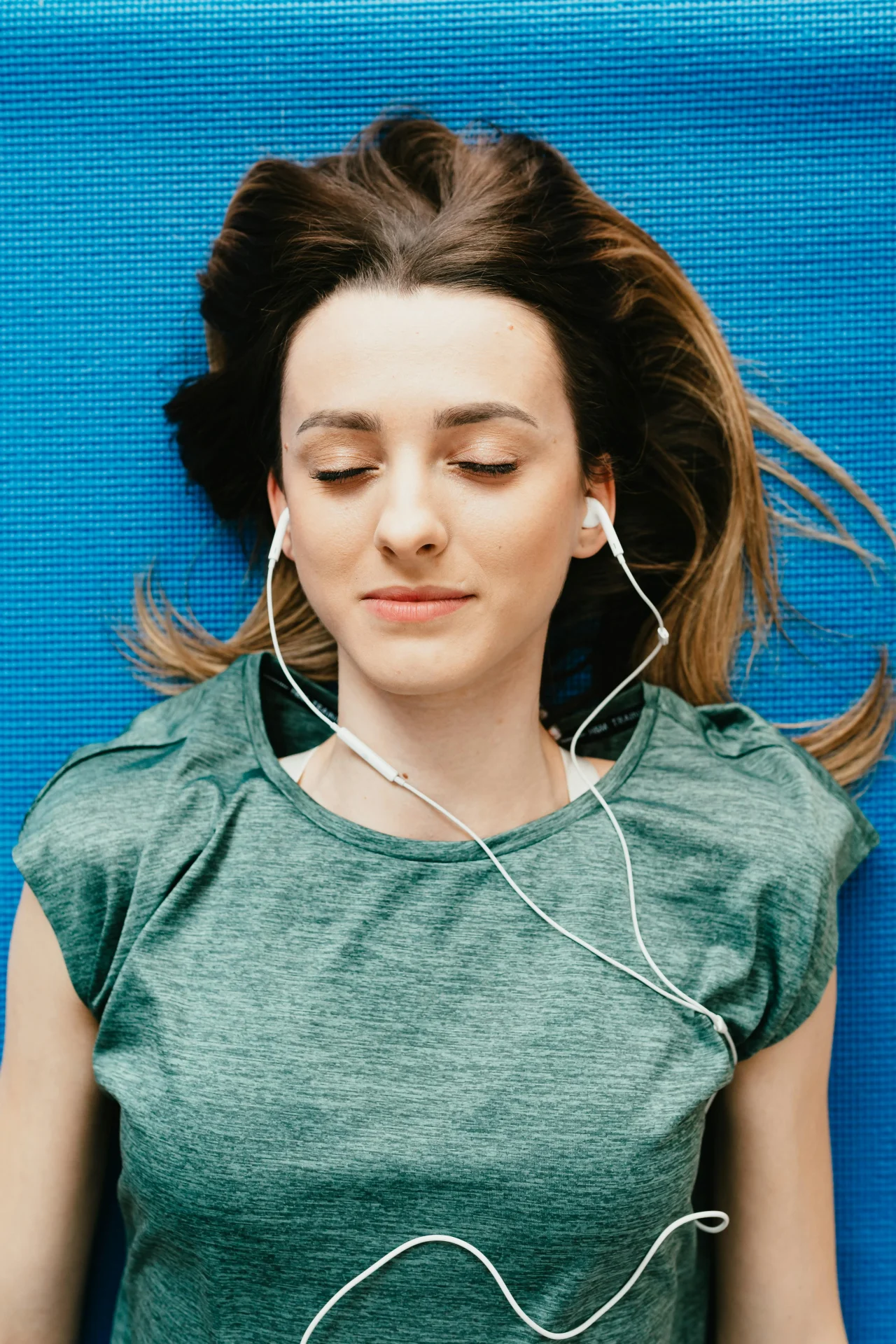 Meditationstechniken 1 Frau liegt und Meditiert mit Kopfhörern als Meditationstechnik