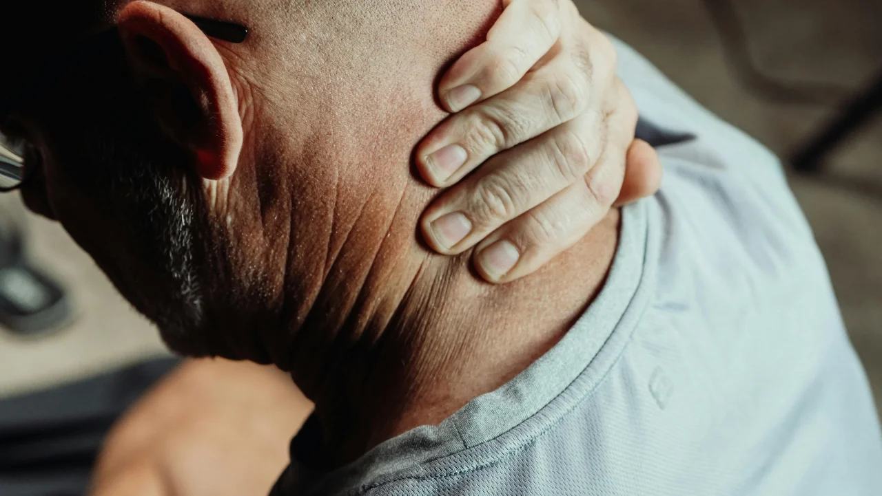 8 Tipps gegen Chronische Schmerzen 1 Mann mit chronischen Nackenschmerzen greift sich in den Nacken