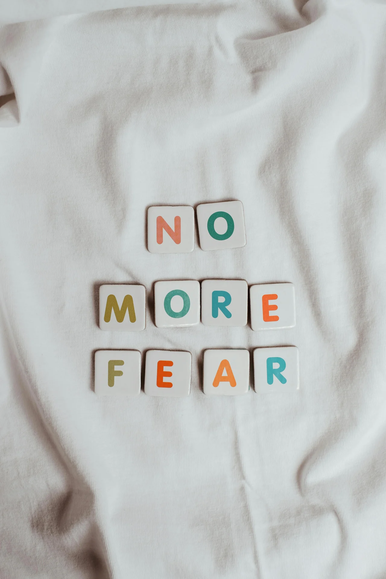 6 Tipps gegen Angst 1 Spielsteine auf dem Bett bilden den Satz No more fear