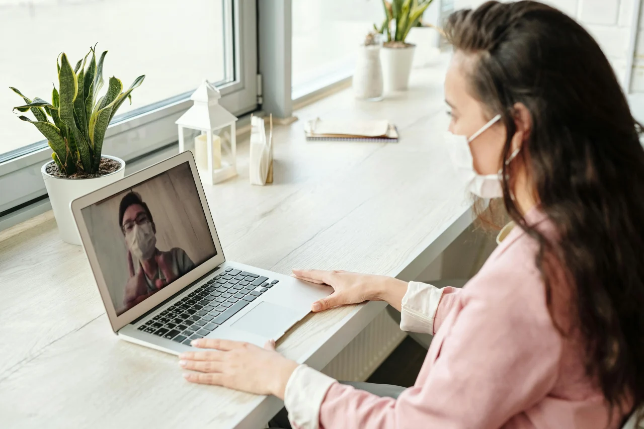 Nach der Pandemie - 3 Tipps 1 Frau mit Corona-Maske führt ein Online-Meeting