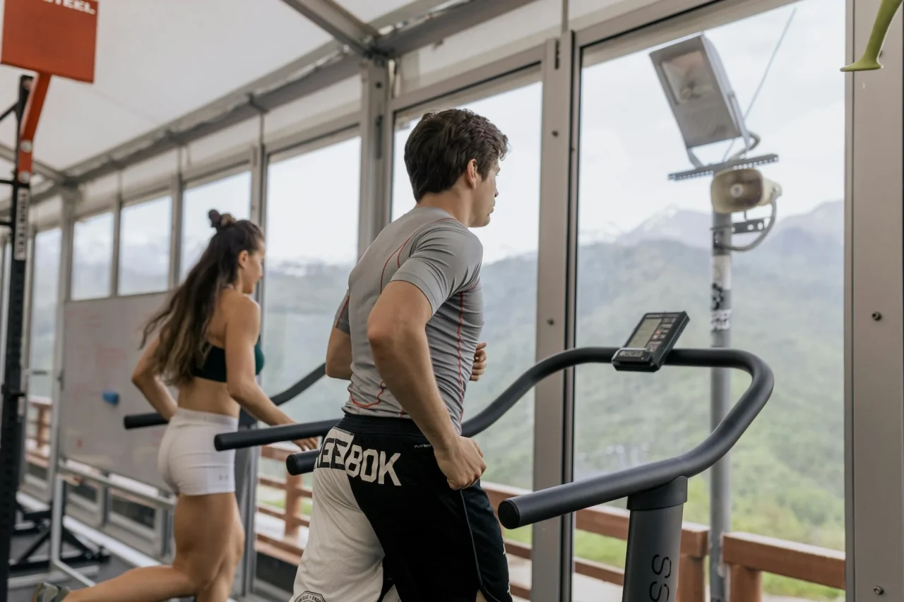 Resilienz stärken durch Training 3 Mann und Frau laufen auf einem Laufband im Fitnessstudio
