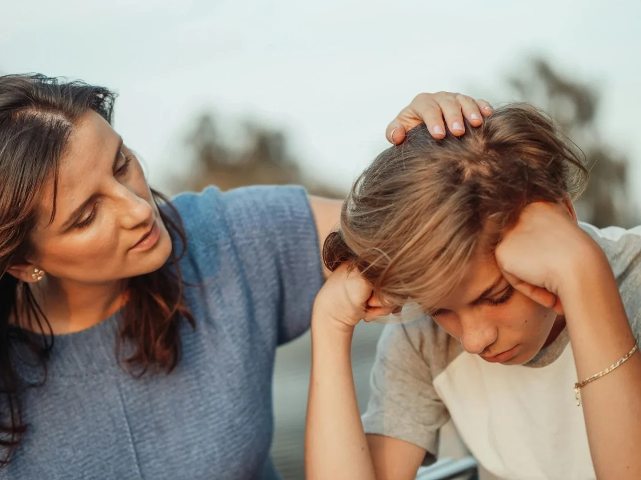 Meditieren mit Kindern: Warum es wichtig sein kann von klein auf das Meditieren zu lernen 1 Mutter tätschelt den Kopf ihres gestressten Sohnes