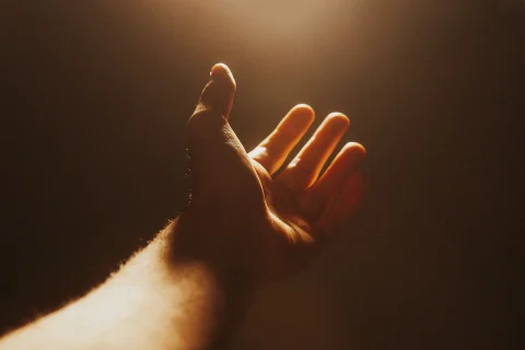 Ausschnitt einer Hand, welche in Sonnenlicht Licht positioniert ist